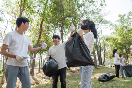 Youth volunteers participating in a community cleanup, promoting sustainability and teamwork.の写真素材
