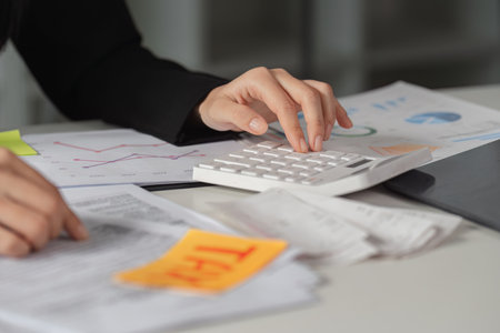 Tax Calculation and Financial Reports. A close-up of tax calculations alongside important documents and a modern calculator.の写真素材