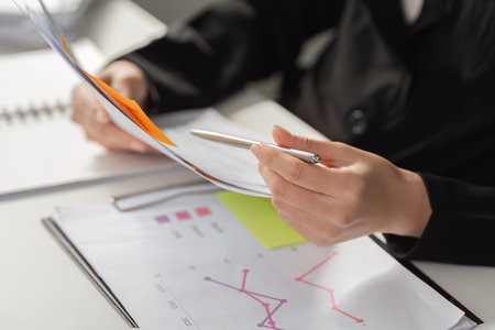 Business Growth and Data Analysis. A business professional analyzing data trends while referring to tax documents.の写真素材
