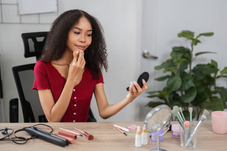 Natural Beauty and Skin Positivity. A woman enhancing her natural beauty with makeup in a cozy environment.の写真素材