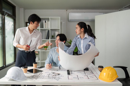 Communication and Coordination. Team members discussing building strategies and plans.の写真素材