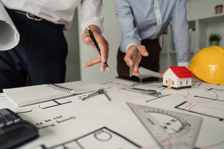 Architectural Planning and Drawing. Close-up of a team discussing blueprints and designs at a work table.の写真素材