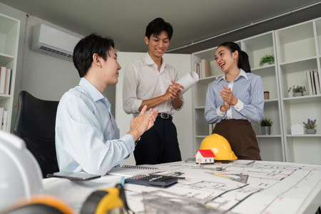 Project Completion and Team Spirit. A team celebrating their successful collaboration on a building design project.の写真素材