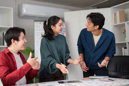 Collaboration and Creative Brainstorming. A dynamic team discussing UI and UX design ideas in a modern workspace.の写真素材