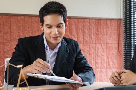 Legal Consultation and Client Engagement. A lawyer discussing important documents with a client in a...