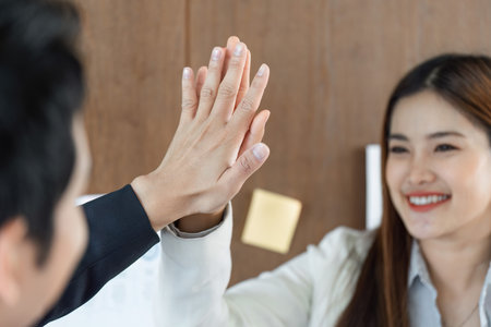 Collaboration and Teamwork. A celebratory high-five highlights a successful partnership in a...