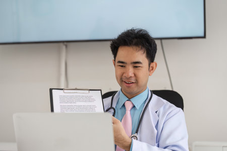 Telemedicine and Patient Consultation. A healthcare professional engaging in a virtual consultation while showing notes on a laptop.の写真素材