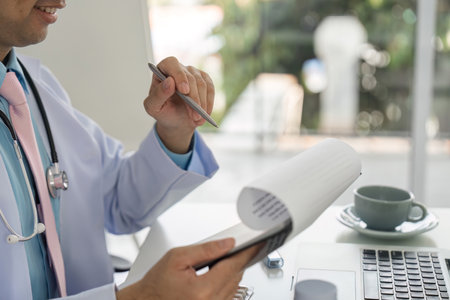 Healthcare Documentation and Medication Management. Doctor reviewing treatment plans while engaging with patients.の写真素材