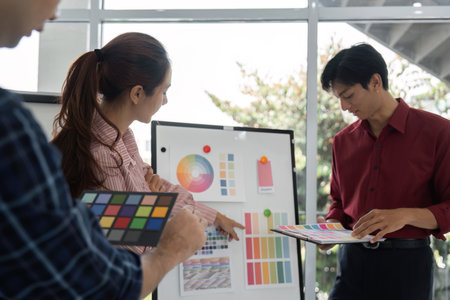 Color Palette Analysis and Teamwork. Team members explore color options in a professional setting.の写真素材