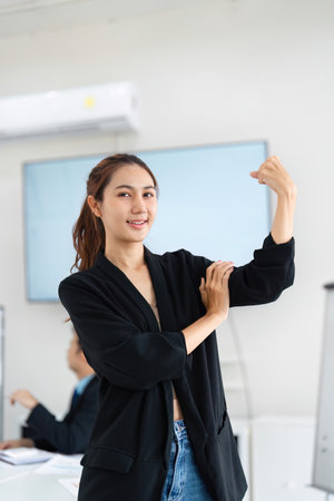 Empowerment and Achievement. A professional confidently showcasing her strength and success in the workplace.の写真素材