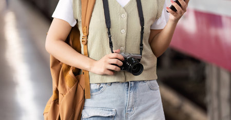 Exploration and Creativity. A woman capturing travel moments at the train station.
