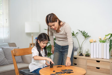 Mother-Daughter Moments and Discovery. A playful game session encourages learning and bonding in a serene environment.の写真素材