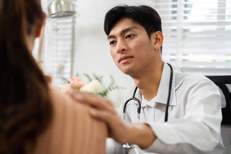 Patient Care and Professional Guidance. A healthcare provider discussing health matters with a patient during a consultation.の写真素材