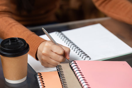 Note-Taking and Idea Development. A student diligently writing notes in a creative workspace.