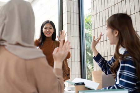 Friendship and Study Sessions. A warm reunion of friends at a cafe, sharing smiles and catching up during a busy school term.の写真素材
