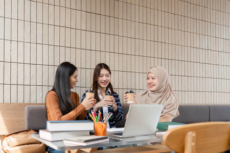 Academic Connection and Coffee Moments. Friends celebrating their time together while studying in a casual cafe setting.の写真素材