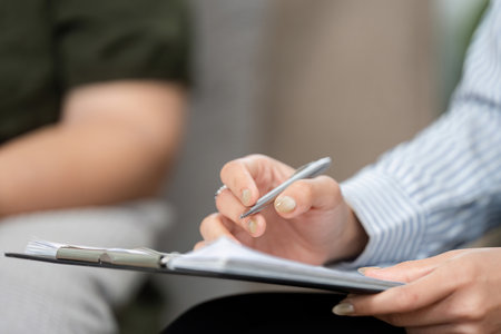 Therapeutic Documentation and Engagement. A psychiatrist noting key points during a client session.の写真素材