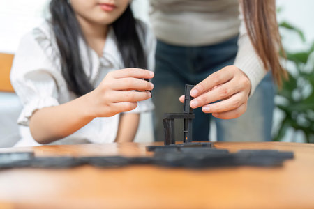 Togetherness in Learning. A mother helping her daughter build strategies while playing.