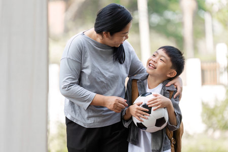 Family and Sports. A mother and son share a joyful moment as they prepare for soccer.の写真素材