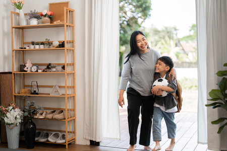 Family Bonding and School Journey. A mother and son walking together after packing for school.の写真素材