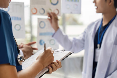 Doctor team discussing patient data and statistics in medical settingの写真素材