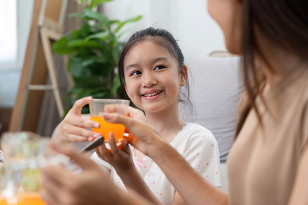 Wellness through healthy eating: Mother and daughter enjoying fresh juicesの写真素材