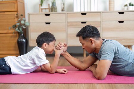 Family engagement with father and son in arm wrestling competitionの写真素材
