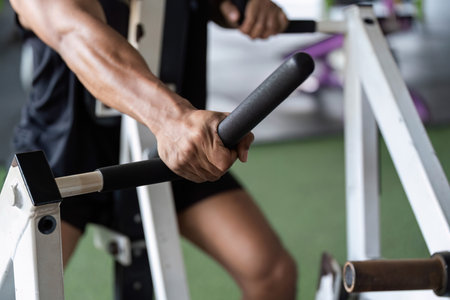 Fitness Training. Close-up of young man gripping gym equipment.