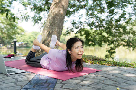 Wellness and Strength. A woman practicing bow pose outdoors.の写真素材
