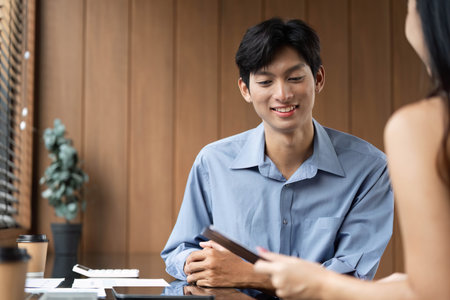 Business Meeting and Collaboration. Young professionals discussing financial reports in a modern office.の写真素材