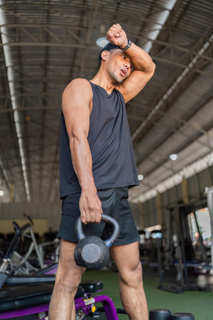 Strength Training. Young man performing kettlebell exercise in gym.の写真素材