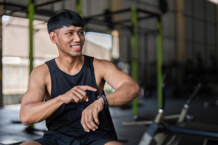 Joyful Fitness Moment: Man Smiling While Checking Smartwatch
