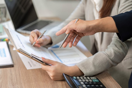 Collaborative Financial Planning. Professional hands reviewing documents in a meeting.の写真素材