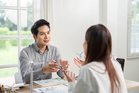 ESG Strategy Discussion. Business professionals engaging in conversation about sustainability initiatives.の写真素材