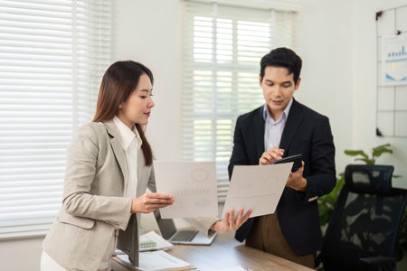 Business Collaboration and Strategy. Professionals discussing project documents in modern office.の写真素材