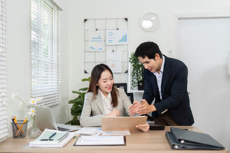 Collaborative Financial Planning. Business partners engaging in financial discussions at a modern office desk.の写真素材