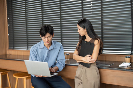 Business Consultation and Collaboration. Two young professionals discussing work-related topics in an office.の写真素材