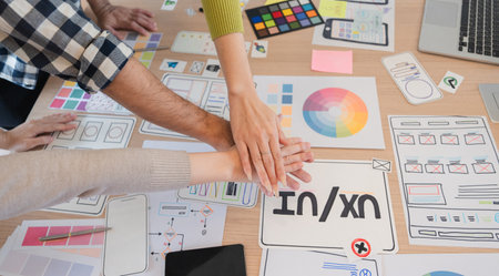 Creative professionals engaged in UX design brainstorming session, showcasing teamwork and innovative ideas.の写真素材