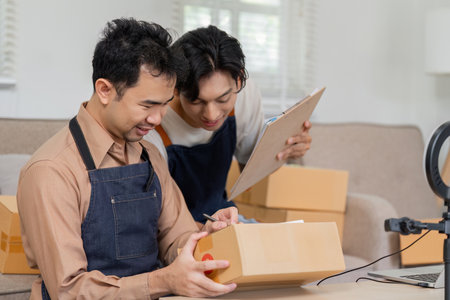 Collaborative online sellers organizing packages and discussing shipment details in a modern workspace.の写真素材