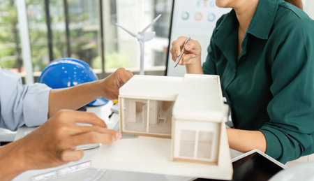 Sustainable Building Design. Engineers discussing eco-friendly architecture and models.