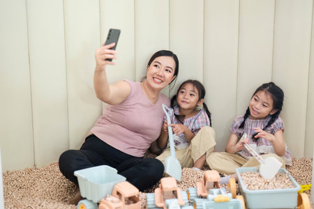 Family Bonding: Mother and Daughters Playing Together in a Playroomの写真素材