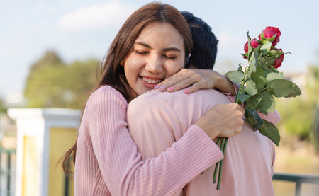 Affectionate couple embracing on Valentines Day, filled with joy and love, surrounded by beautiful rosesの写真素材