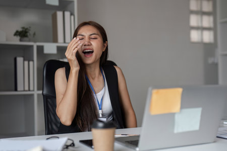 Office Workers Experiencing Sneezing and Allergy Symptoms in a Modern Workplace Environmentの写真素材