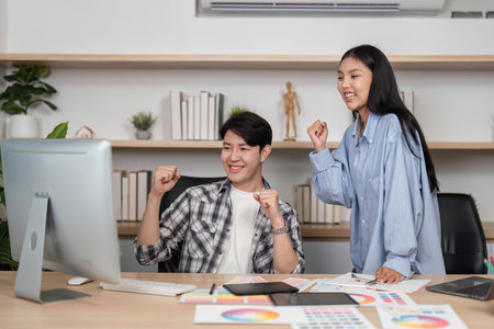 Joyful Designers in UX and UI. Two colleagues celebrate their success with excitement in a modern office.の写真素材