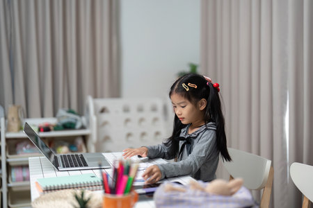 Focused Learning: Young Girl Engaged with Laptop at Home
