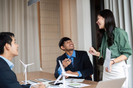 ESG Focused Teamwork. Engaged professionals brainstorming sustainable solutions in a conference room.の写真素材