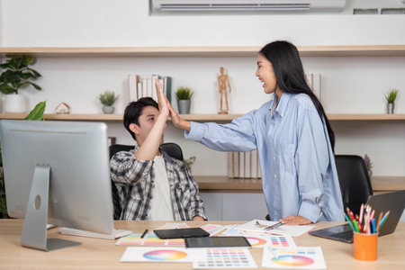 High-Five Moment in UX and UI Design. Designers celebrate a milestone with a joyful high-five.の写真素材