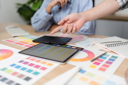 UX and UI Design Collaboration. Creative team discussing color palettes and design elements.の写真素材