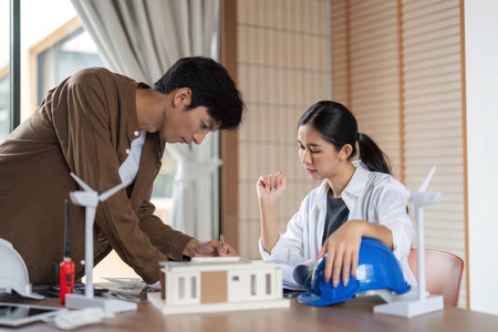 Sustainable Design Collaboration. Young architects discussing eco-friendly building plans.の写真素材
