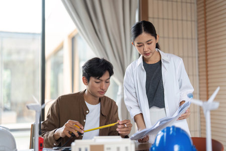 ESG Collaboration in Sustainable Architecture. Young professionals discussing eco-friendly building plans.の写真素材